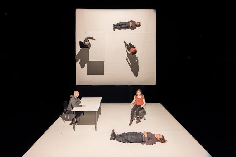 Two stages on which people are sitting at a desk and lying down