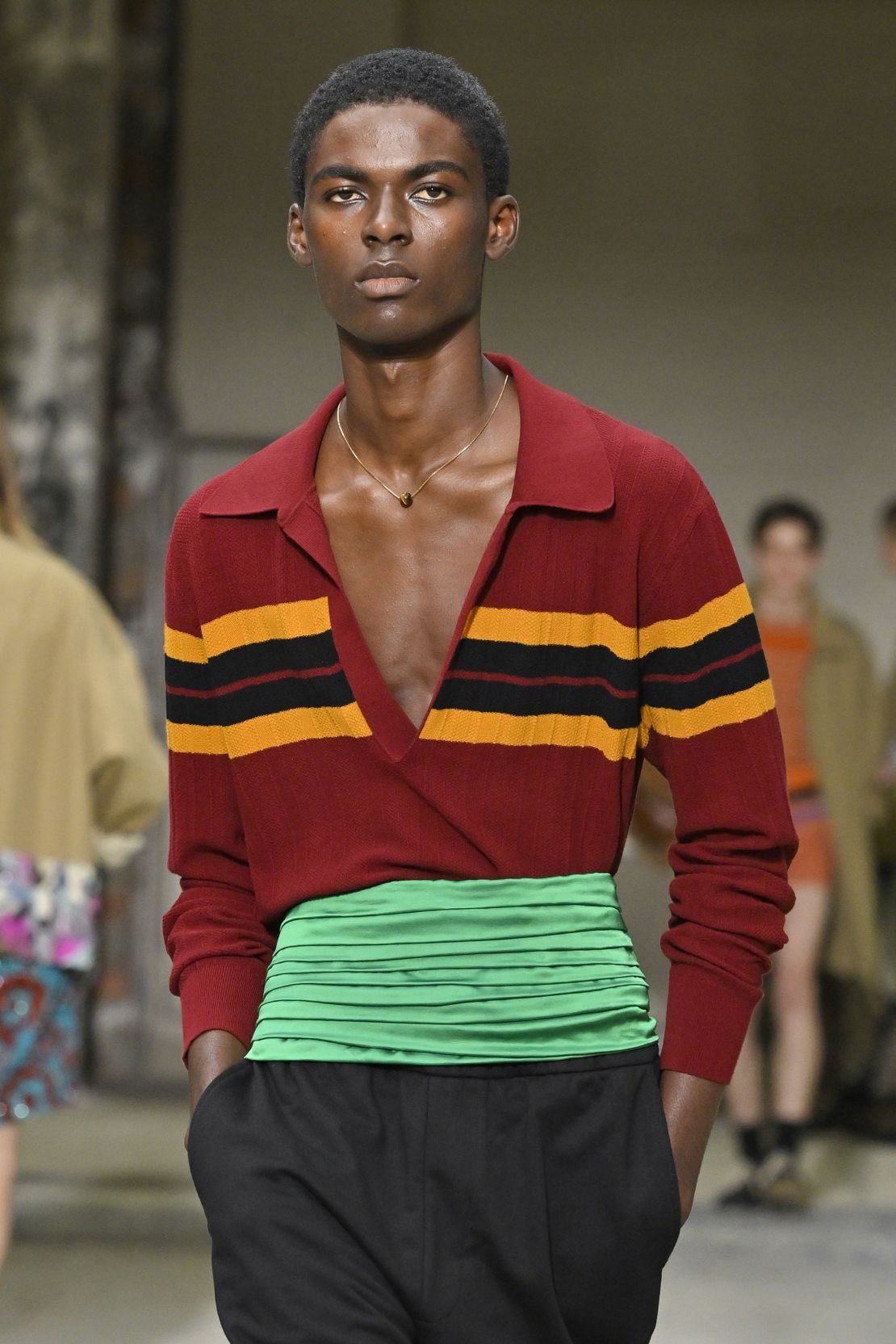 A jewel-toned cumberbund over a low-cut polo at Dries Van Noten.