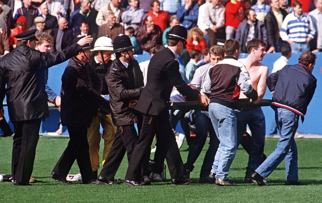 An injured supporter is carried on a makeshift stretcher during the Hillsborough disaster in 1989.