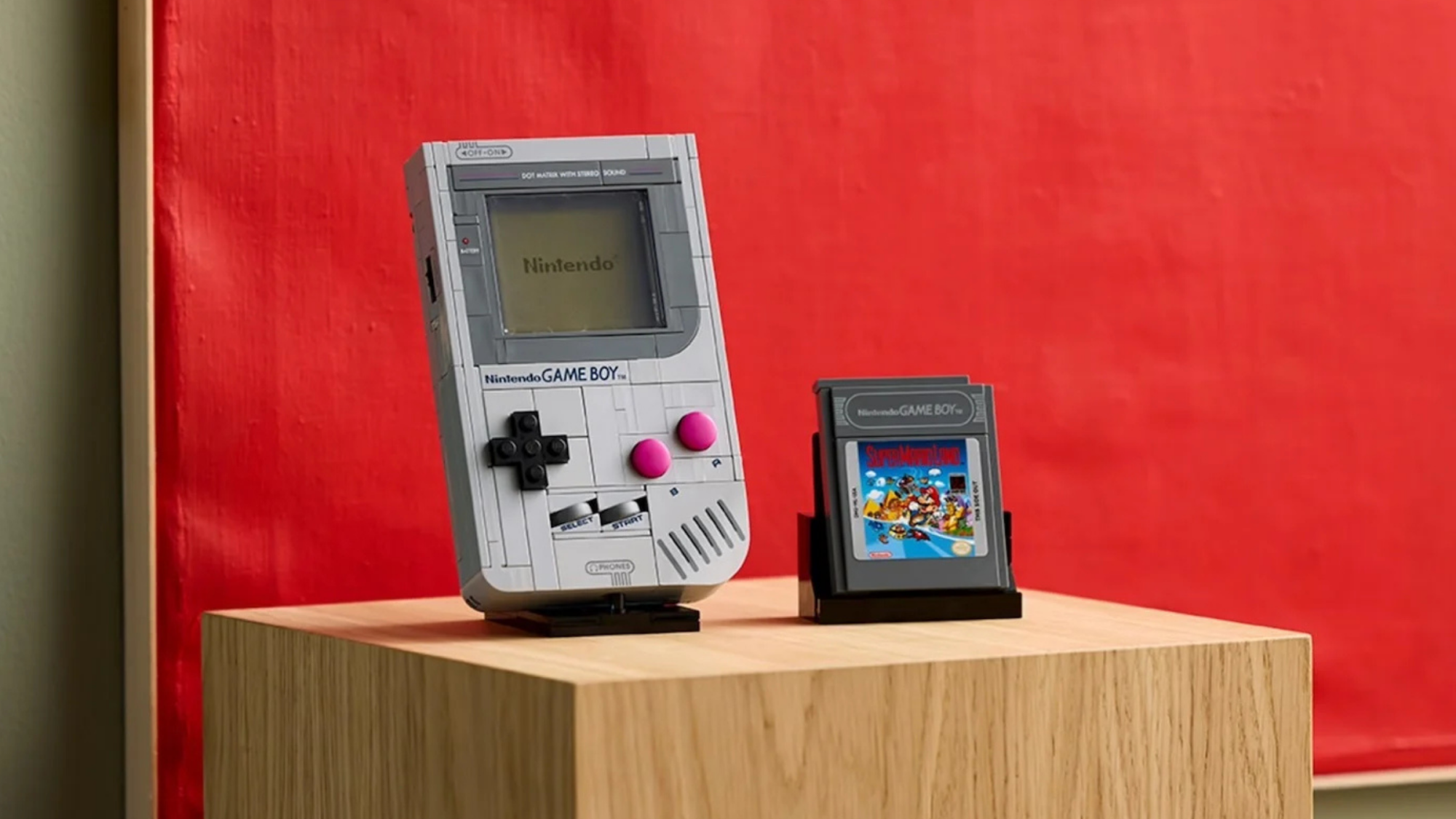 the lego super mario game boy set with a cartridge on a wooden block