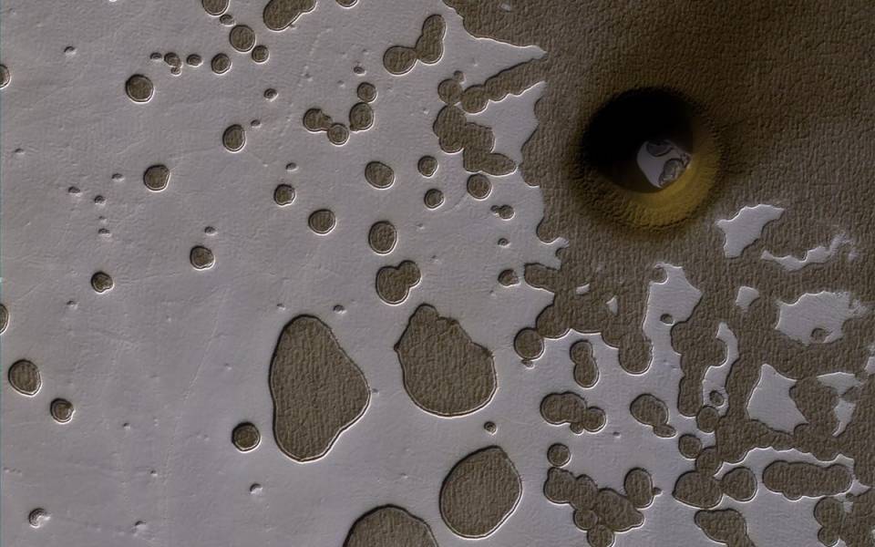 Mars surface with impact crater and patterned ground.