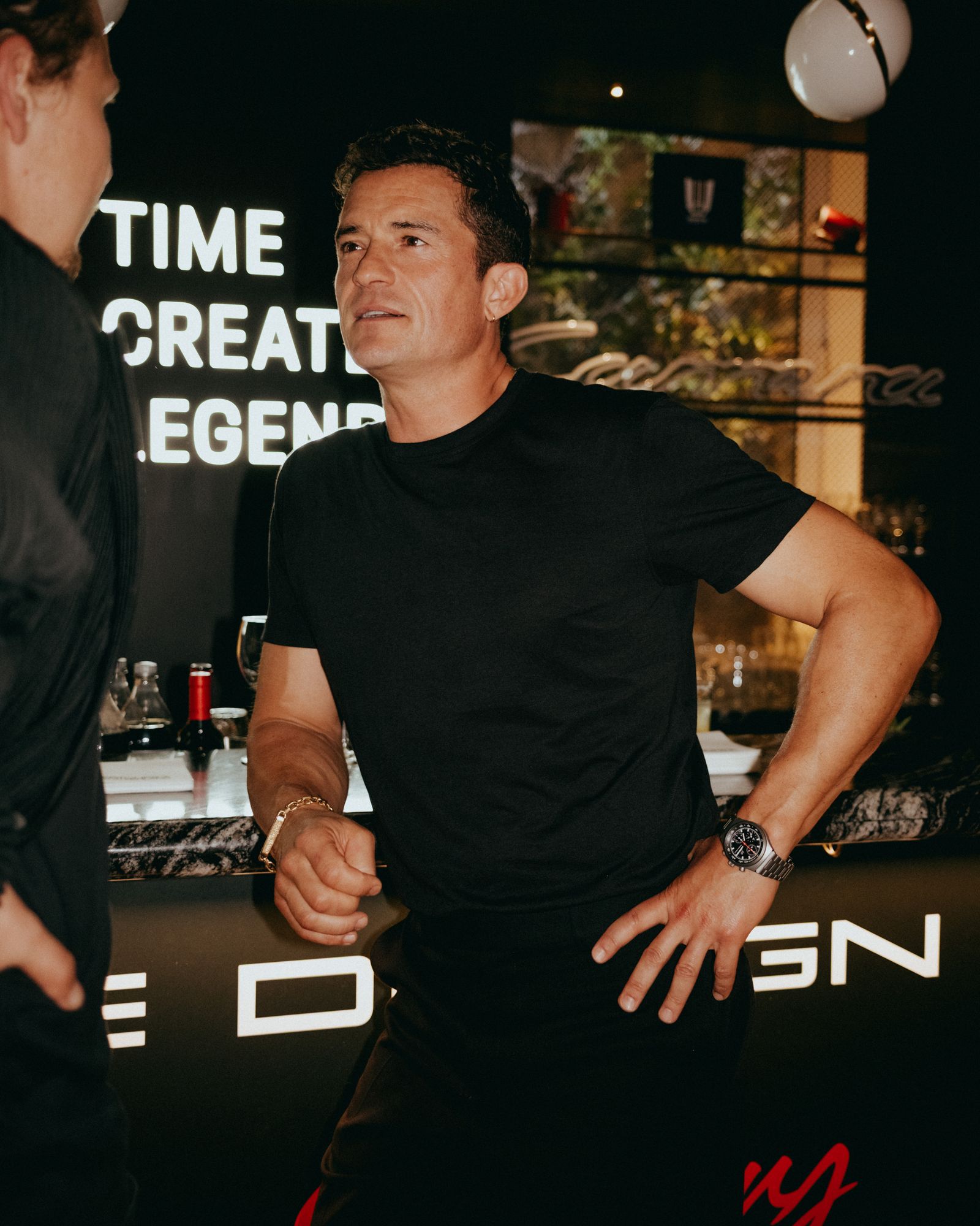 Image may contain Orlando Bloom Wristwatch Adult Person Clothing TShirt Lamp Fashion and Sleeve