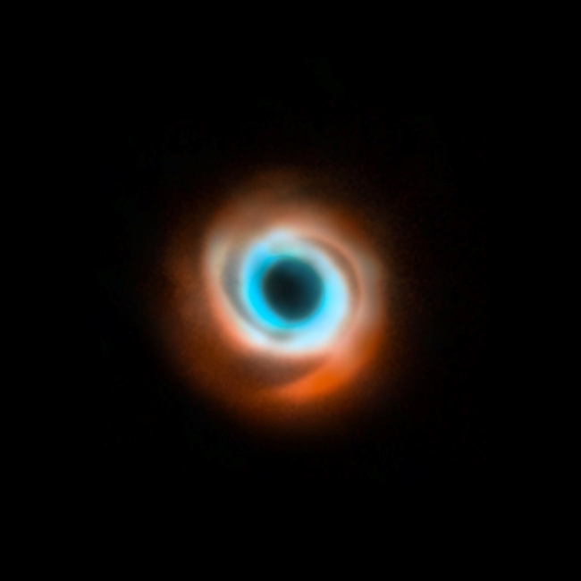 On a black background, a light blue swirl around a dark center, with a larger orange swirl around the blue.
