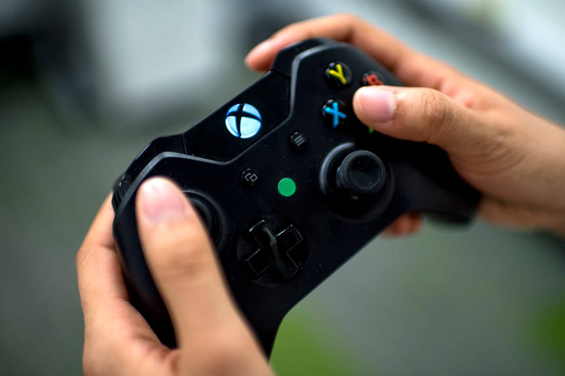 Hands holding an X-Box gaming remote.
