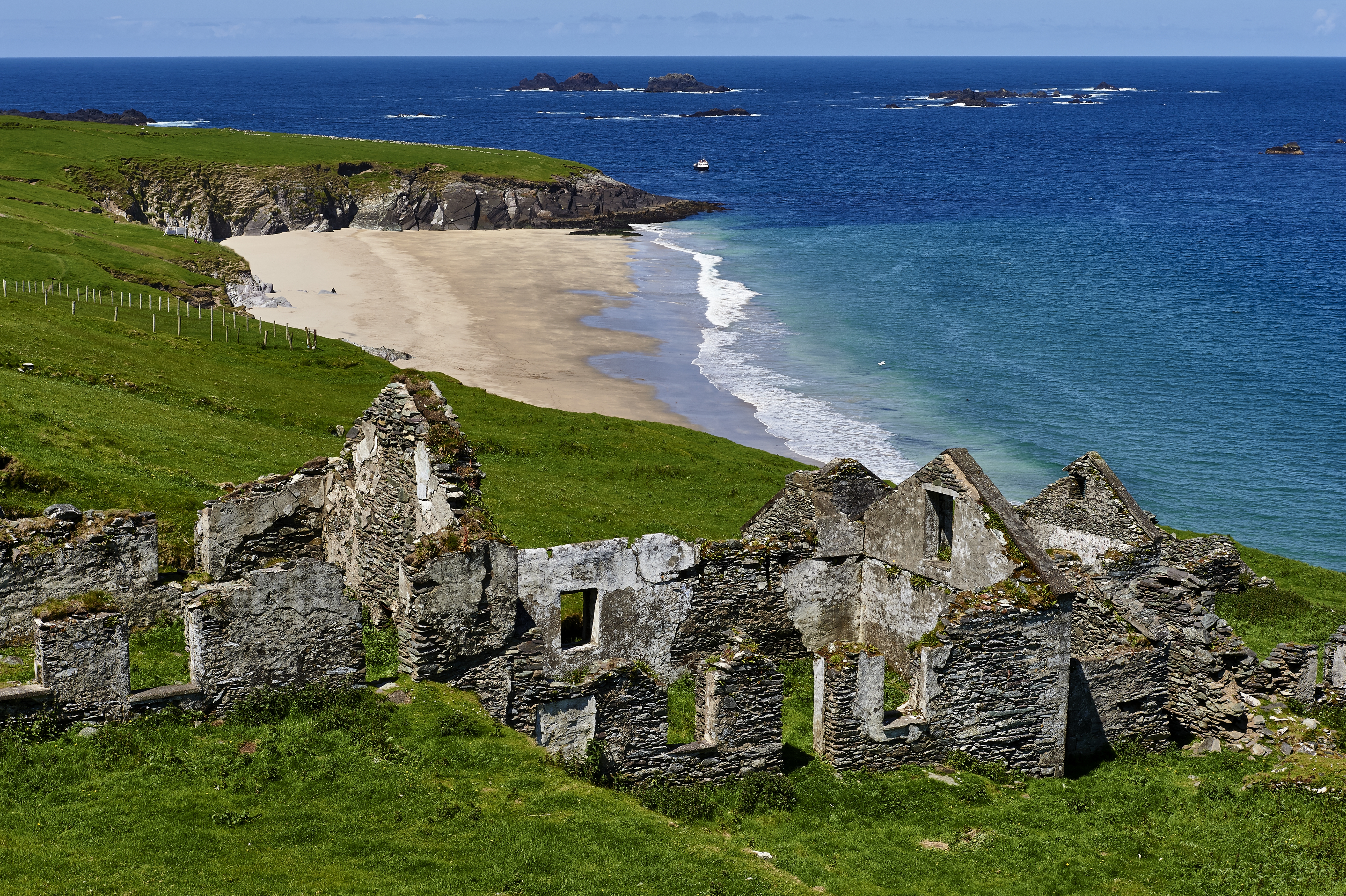 Ruins overlooking a sandy beach and ocean on the Blasket Islands, Ireland.