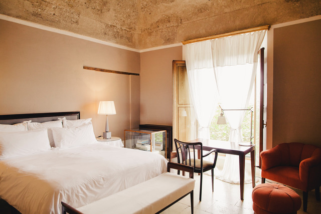 Bedroom with a king-size bed, seating area, and view.