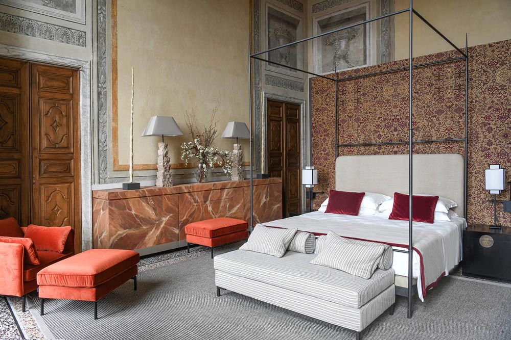 Palazzo Durazzo Hotel room with four-poster bed and seating area.