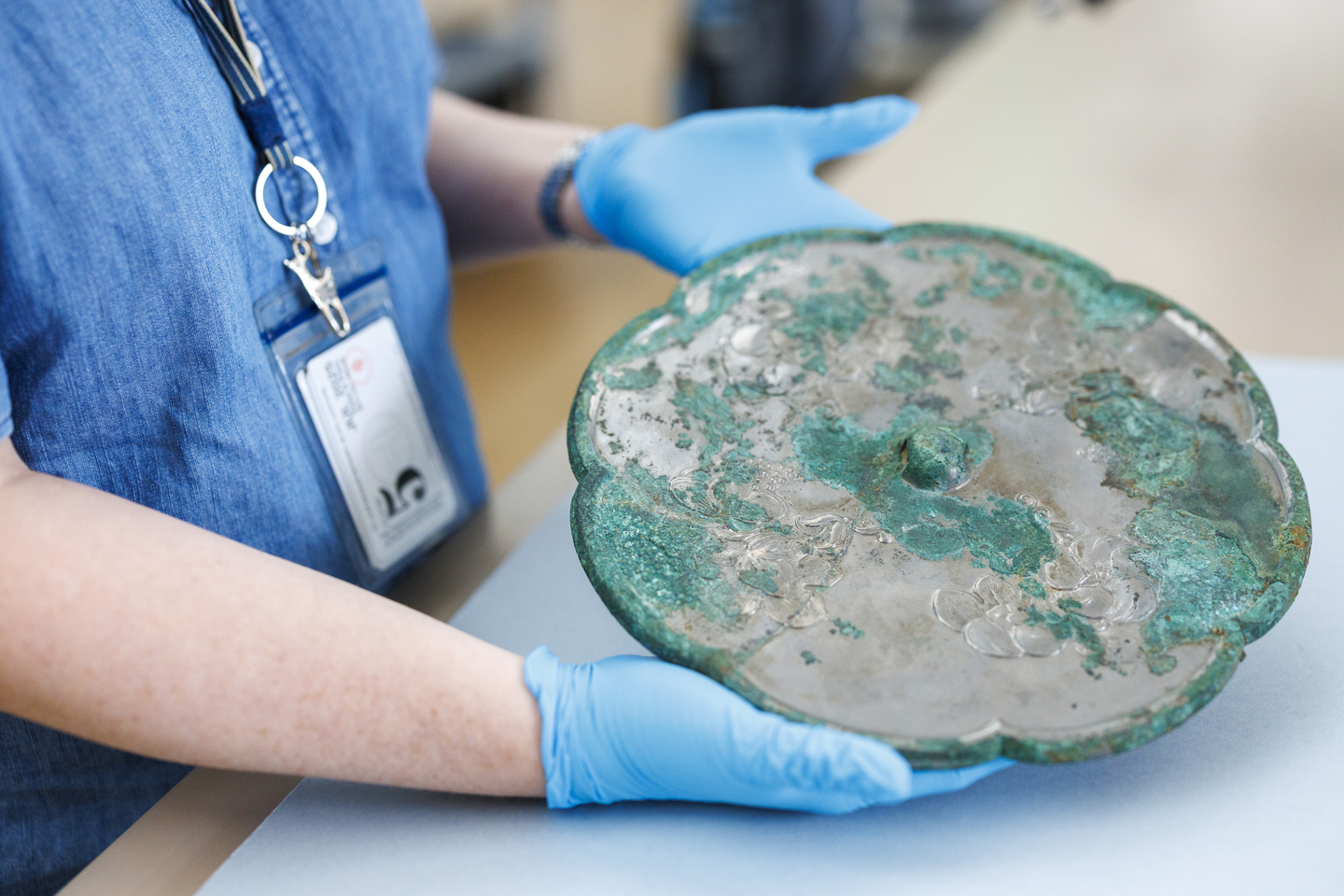 Susan Costello holds an eight-lobed mirror from the 8th-century Tang dynasty.