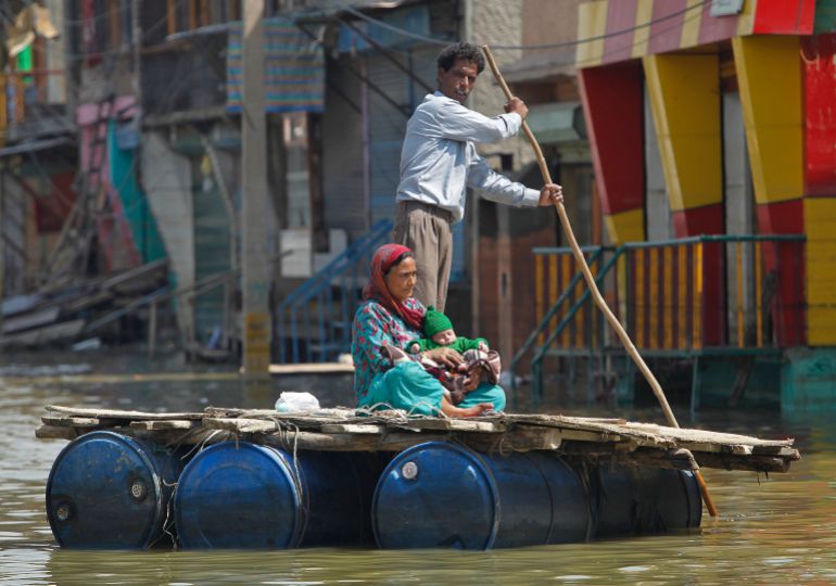 A Kashmiri man rows a makeshift raft carrying a woman and a child through the flood waters in Srinagar September 20, 2014. Both the Indian and Pakistani sides of the disputed Himalayan region have seen extensive flooding this month with Srinagar particularly hard hit. Hundreds of people have been killed and tens of thousands are homeless. REUTERS/Danish Ismail (INDIAN-ADMINISTERED KASHMIR - Tags: DISASTER TPX IMAGES OF THE DAY)