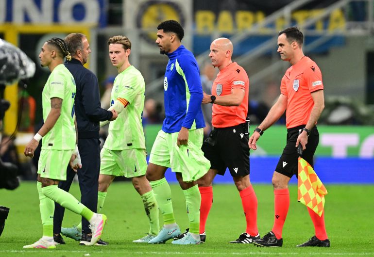 Barcelona coach Hansi Flick remonstrates with referee Szymon Marciniak at the end of the first half of the Champions League second leg tie against Inter Milan