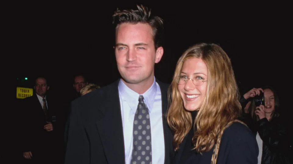 Matthew Perry and Jennifer Aniston smiling together at an event, dressed in formal attire.