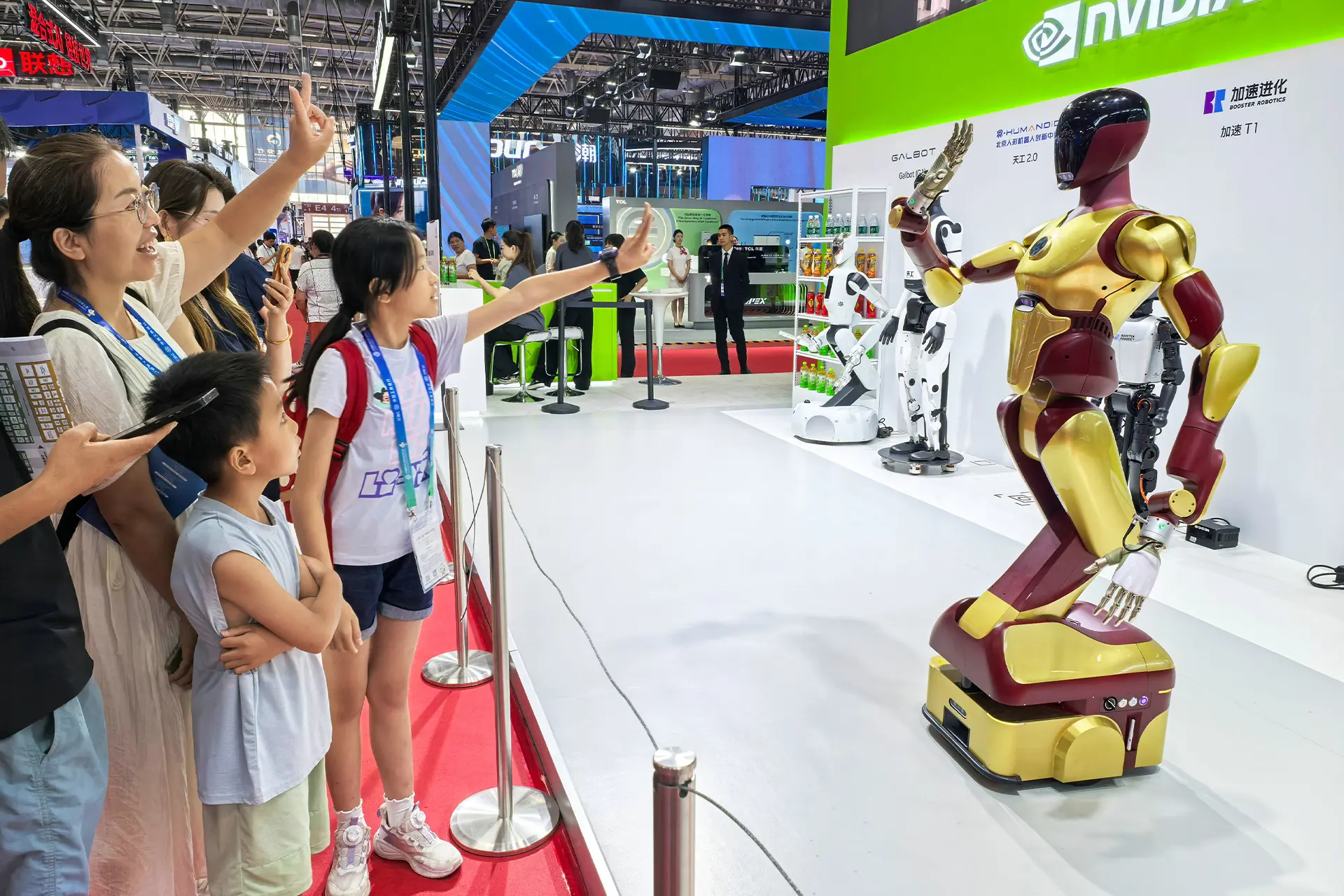 A group of people waving to a robot in a large exhibition space