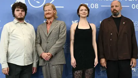 Getty Images US actor Aidan Delbis, US actor Jesse Plemons, US actress Emma Stone and Greek director and screenwriter Yorgos Lanthimos attend a photocall for the movie "Bugonia" presented in competition at the 82nd International Venice Film Festival, at Venice Lido on August 28, 2025