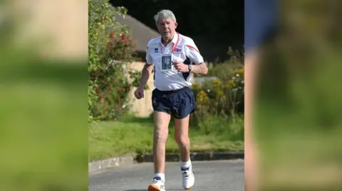 Bradford NHS Hospital Trust Mike Gibbons wearing blue shorts and a white tshirt running 
