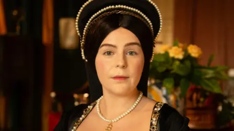Daniel Watson Close up shot of West End performer Emily Lane who is playing Anne Boleyn in the musical wearing the queen's outfit with headdress and necklace