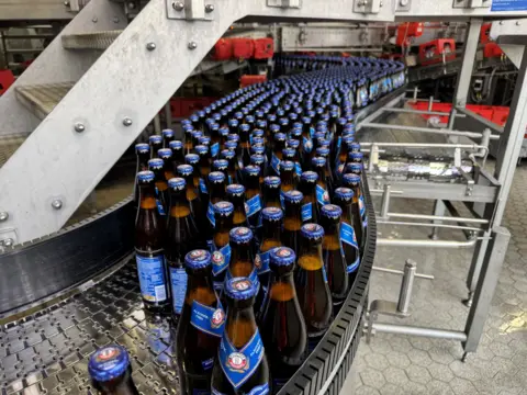 Bottles of the non-alcoholic beer, Erdinger, on a conveyor belt.