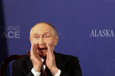 Getty Images Putin gestures to reporters after being asked, "Will you you stop killing civilians?"
