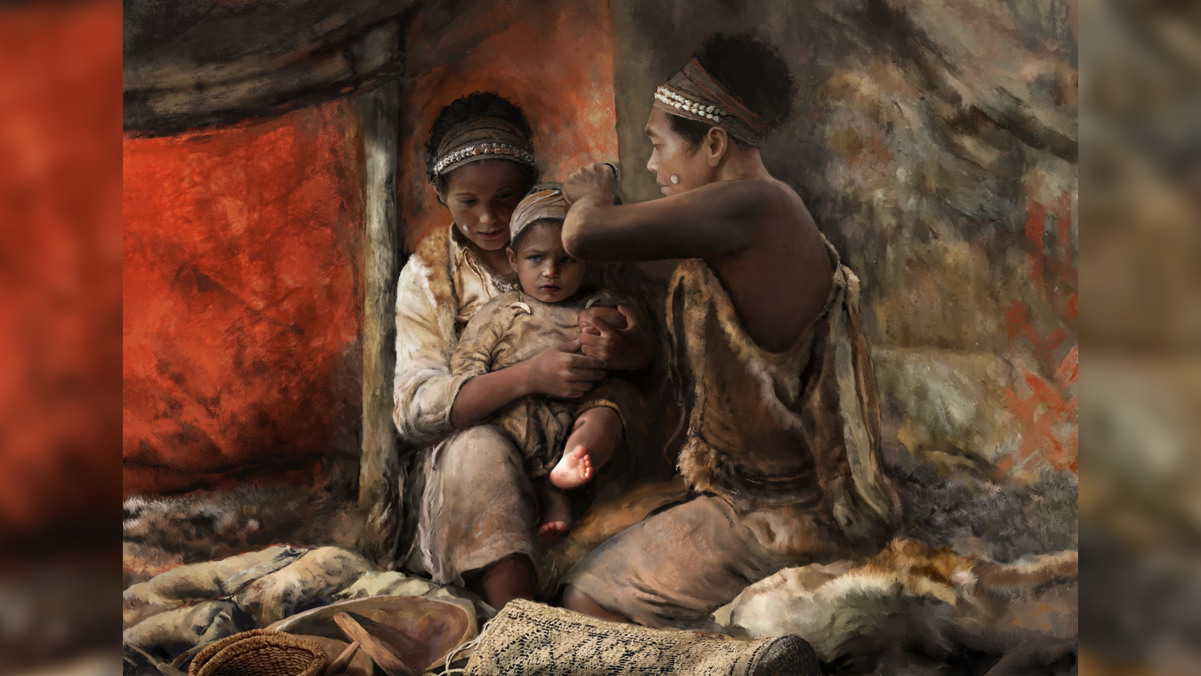 two brown-skinned people in a cave wrap a baby's head with a piece of fabric