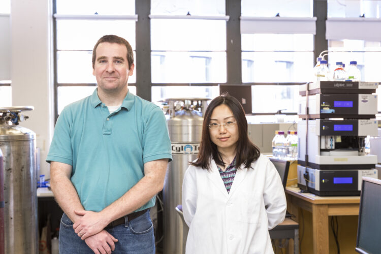 Senior author Michael Dodd and lead author Huan He stand side by side in their lab.
