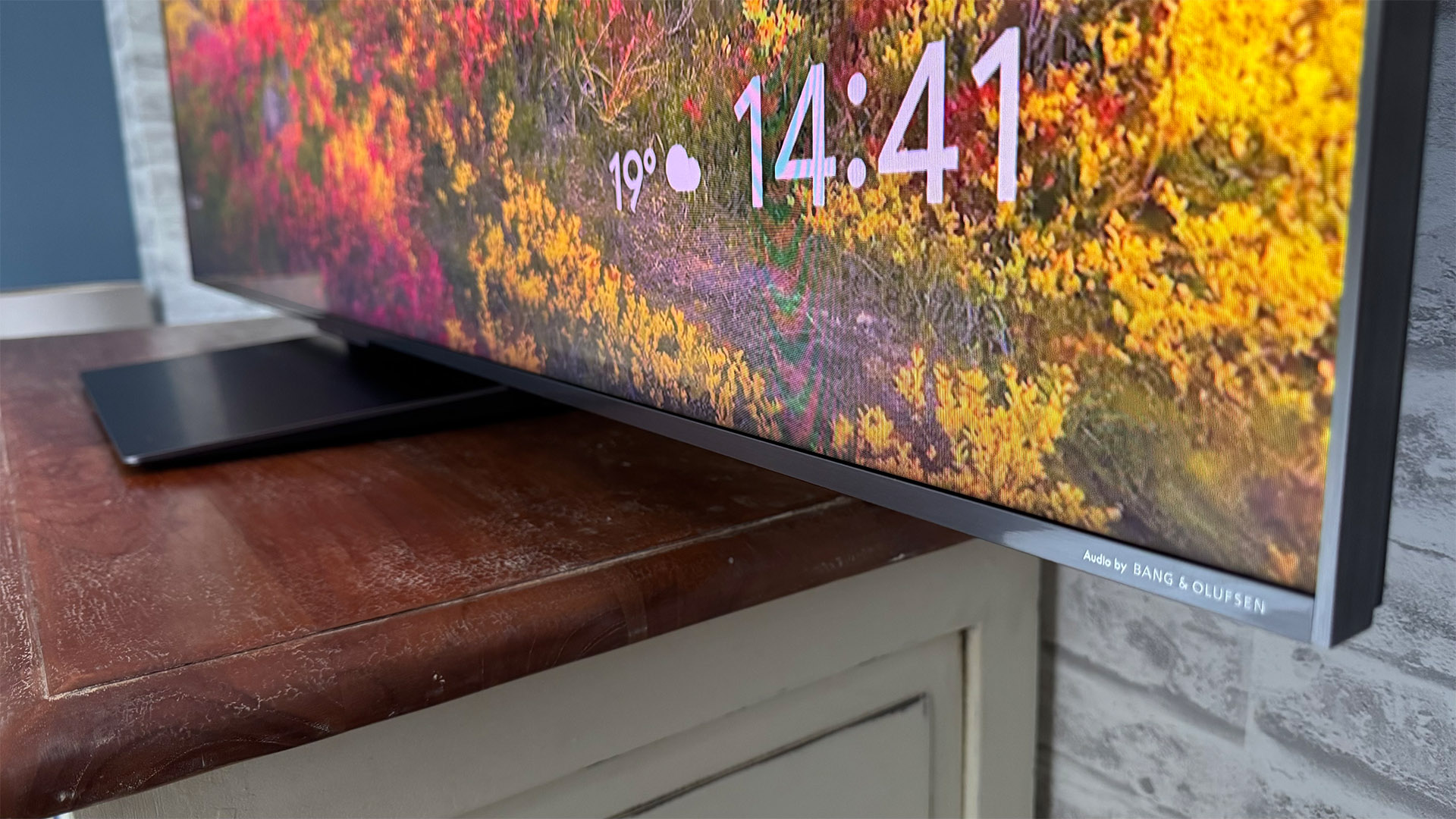 TCL 65C8K LCD TV bottom right edge of TV with flowers on screen, temperature and time shown