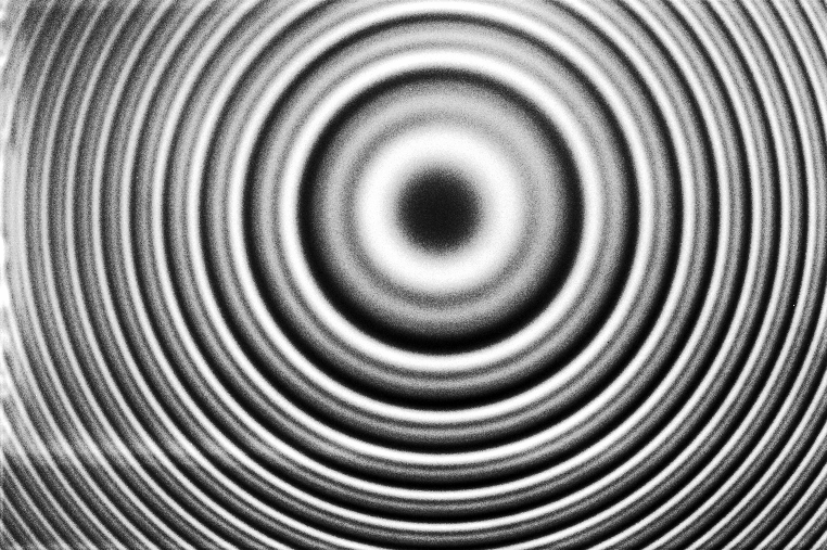 Monochrome concentric circles radiate from a central point, creating a ripple-like pattern reminiscent of nature’s own design.