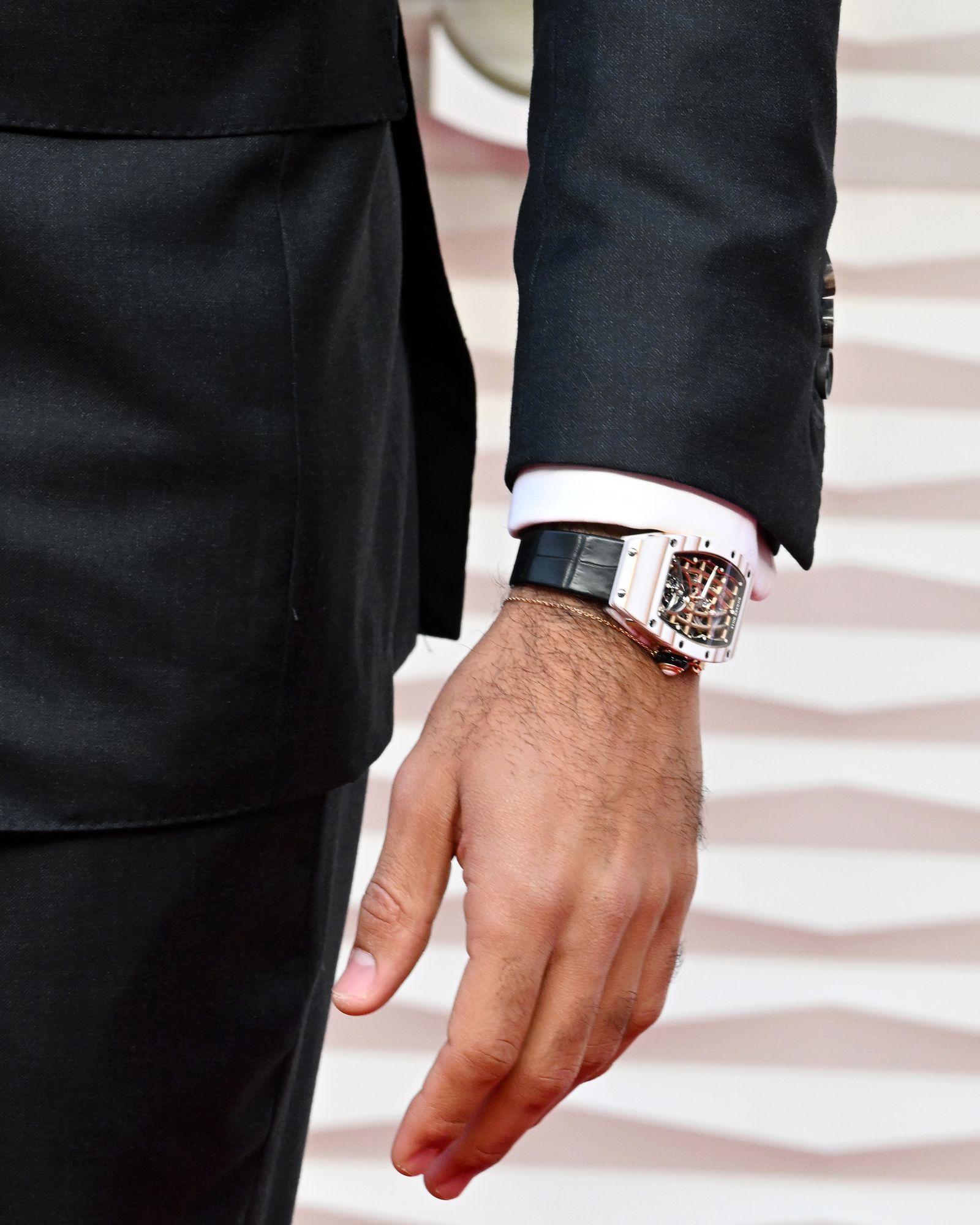 Image may contain Adult Person Body Part Hand Clothing Formal Wear Suit Finger Cuff Accessories and Bracelet