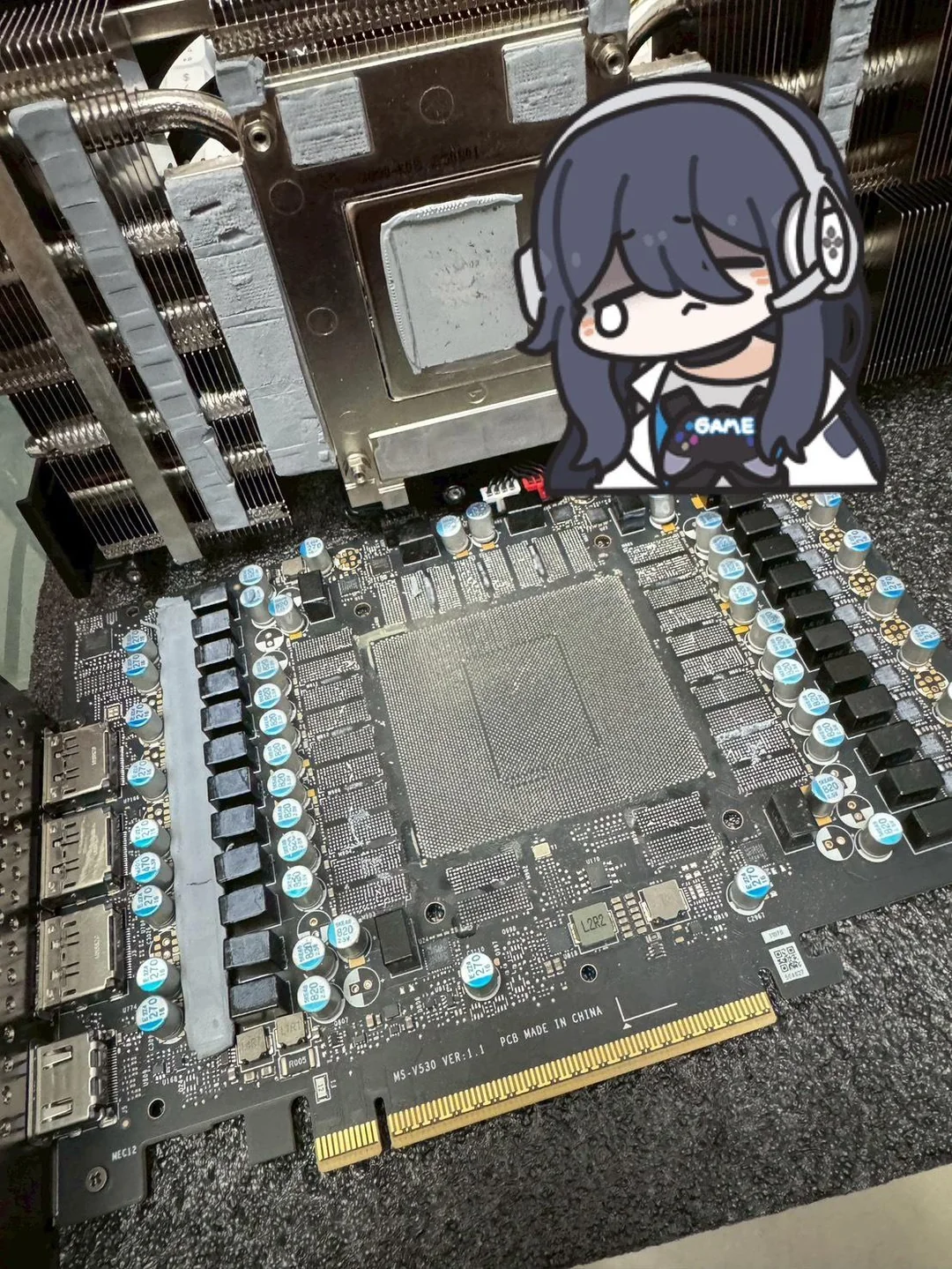 Graphics card and cooling system with a cartoon character overlay in a tech setup.