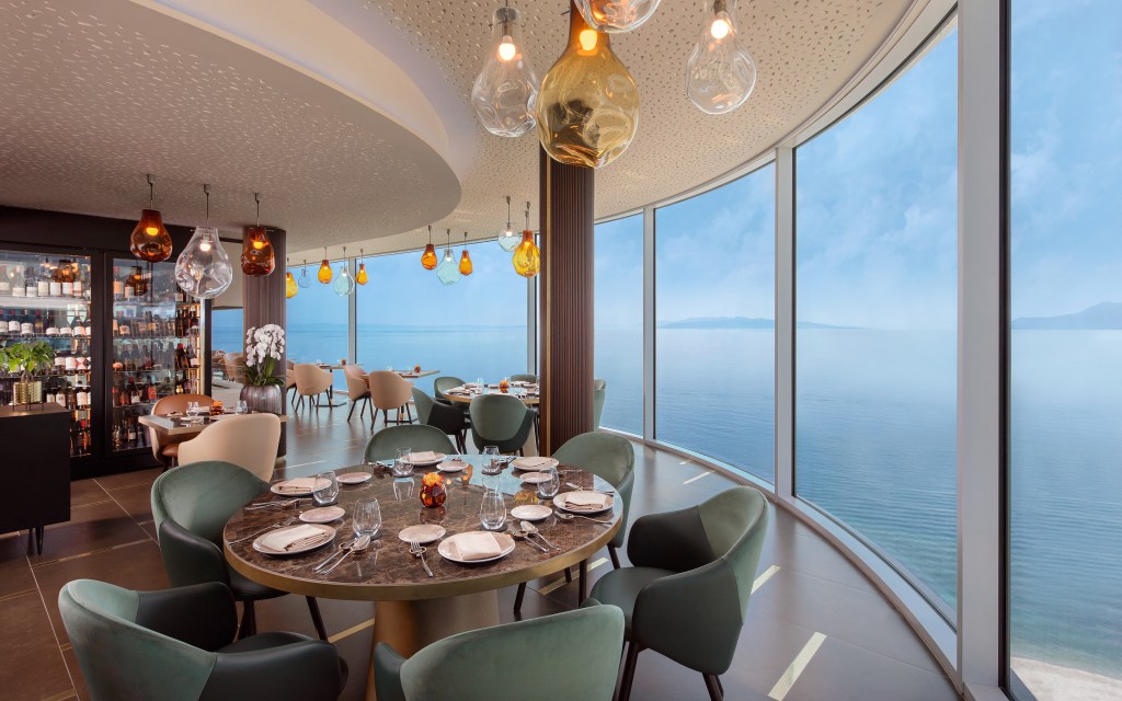 Nebo Restaurant & Lounge at Hilton Rijeka Costabella Beach Resort & Spa dining room seating area with windows from floor to ceiling overlooking water