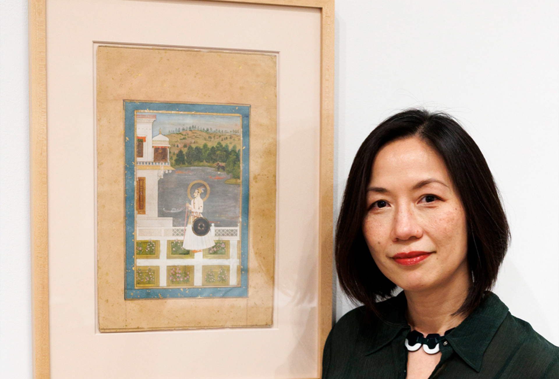 Janet O'Brien stands with a painting. 