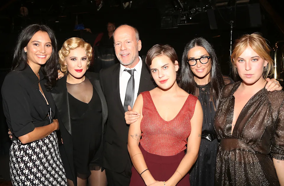 Bruce Willis and Demi Moore pose with their daughters and Emma Heming Willis, all dressed in formal attire.