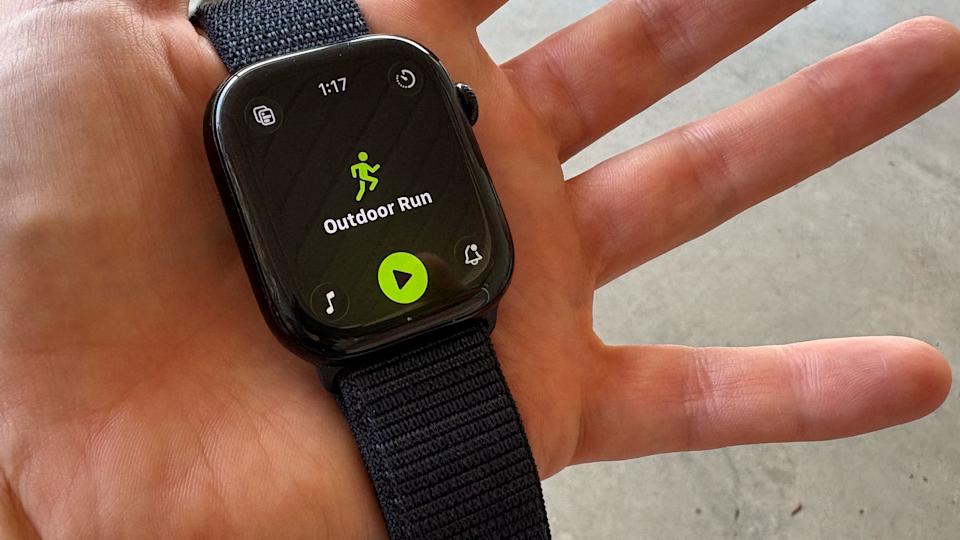 A person holds an apple watch 10 displaying the new workout app