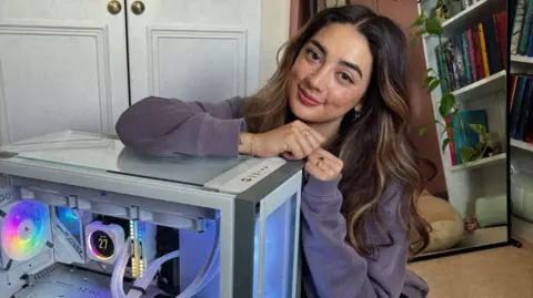 Alyce Rocha Alyce Rocha kneeling next to her PC at home. She has brown eyes and brunette hair, with blonde highlights