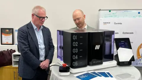 West Midlands Mayor Richard Parker looking at a potential commercial prototype model, after previously being shown the process in action with older equipment.