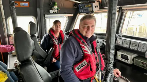 Allan Thornhill Helen and Allan Thornhill wearing life jackets on board the lifeboat at RNLI Buckie in Scotland