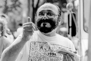 American Latin Jazz pianist, composer, and band leader Eddie Palmieri gives a thumbs up sign as he holds a hot dog beside a vendor's cart (at 5th Avenue and E 72nd Street), New York, New York, August 12, 1990. He wears a Central Park SummerStage t-shirt, after having performed at the event. (Photo by Jack Vartoogian/Getty Images)