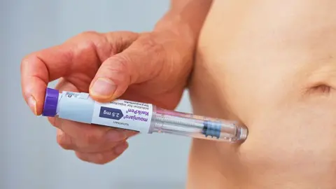 Getty Images A person injecting the weight-loss drug Mounjaro.