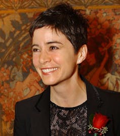 A woman smiling with rose corsage.