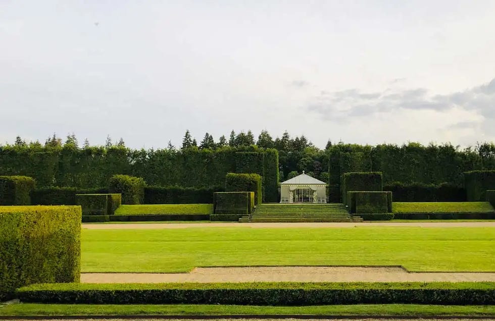 formal garden layout with manicured hedges and a central structure