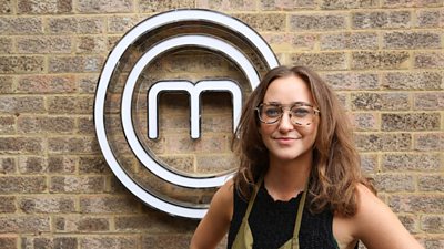 A portrait image of a contestant stood against an exposed brick wall, with the MasterChef logo behind her.