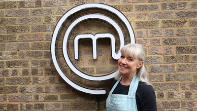 A portrait image of a contestant stood against an exposed brick wall, with the MasterChef logo behind her.