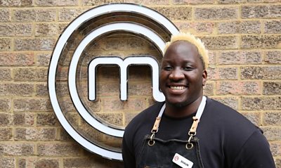 A portrait image of a contestant stood against an exposed brick wall, with the MasterChef logo behind him.