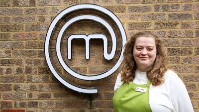 A portrait image of a contestant stood against an exposed brick wall, with the MasterChef logo behind her.