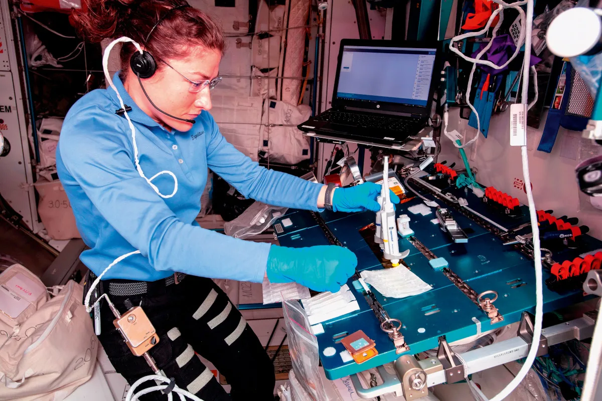 Photo of an astronaut performing tests in the lab aboard the ISS