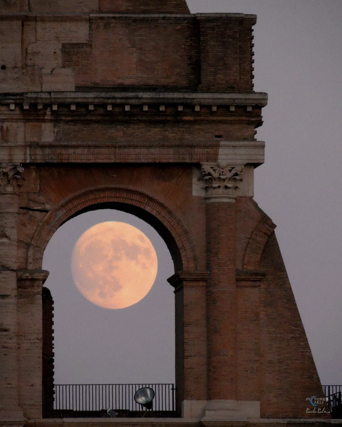 Nearly-full Sturgeon Moon captured through the arches of the Colosseum in Rome, Italy, by Paolo Palma, 7 August 2025. Equipment: Nikon Coolpix p510 camera, single shot
