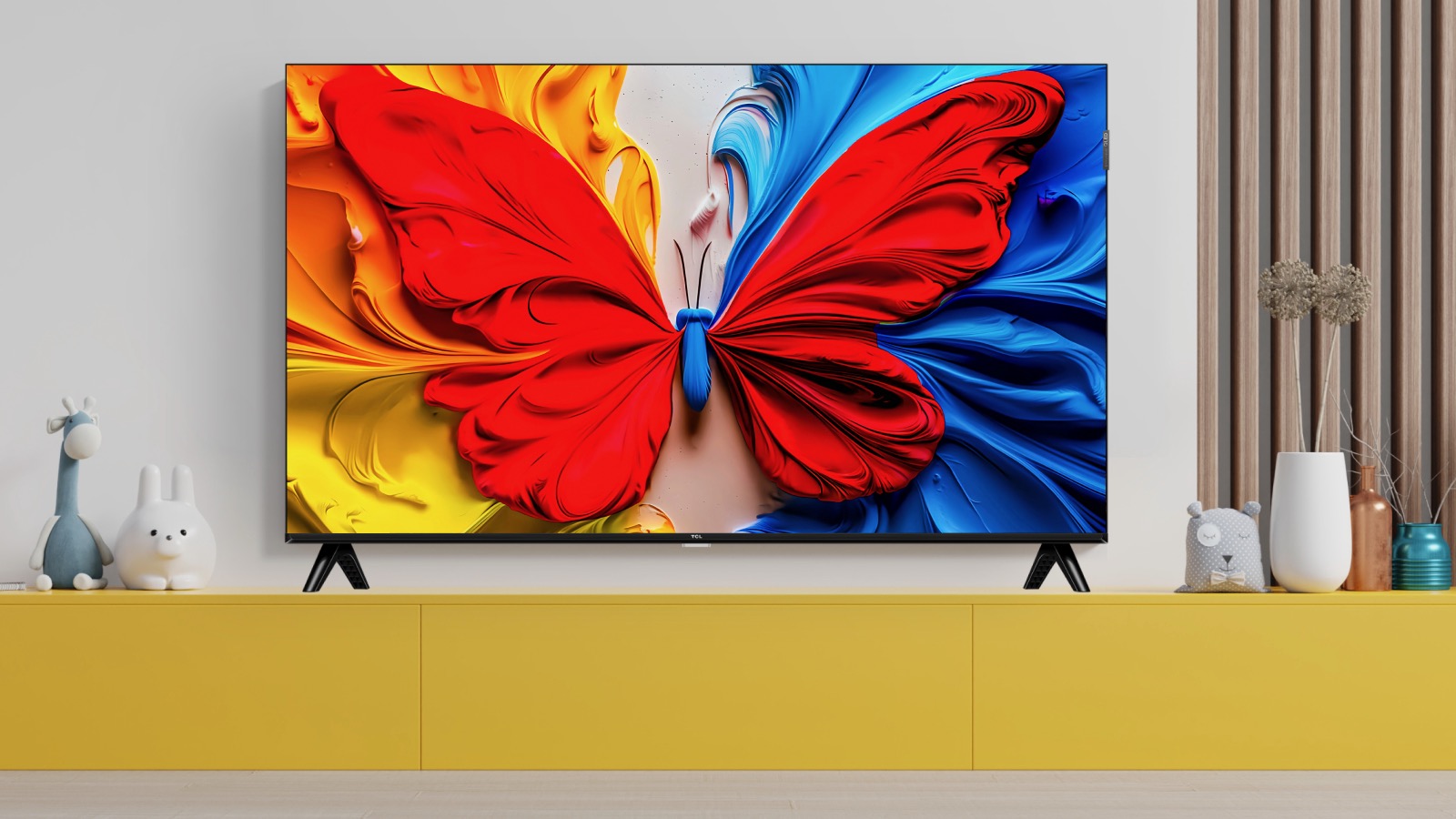 A TCL S5K TV on a yellow side unit.