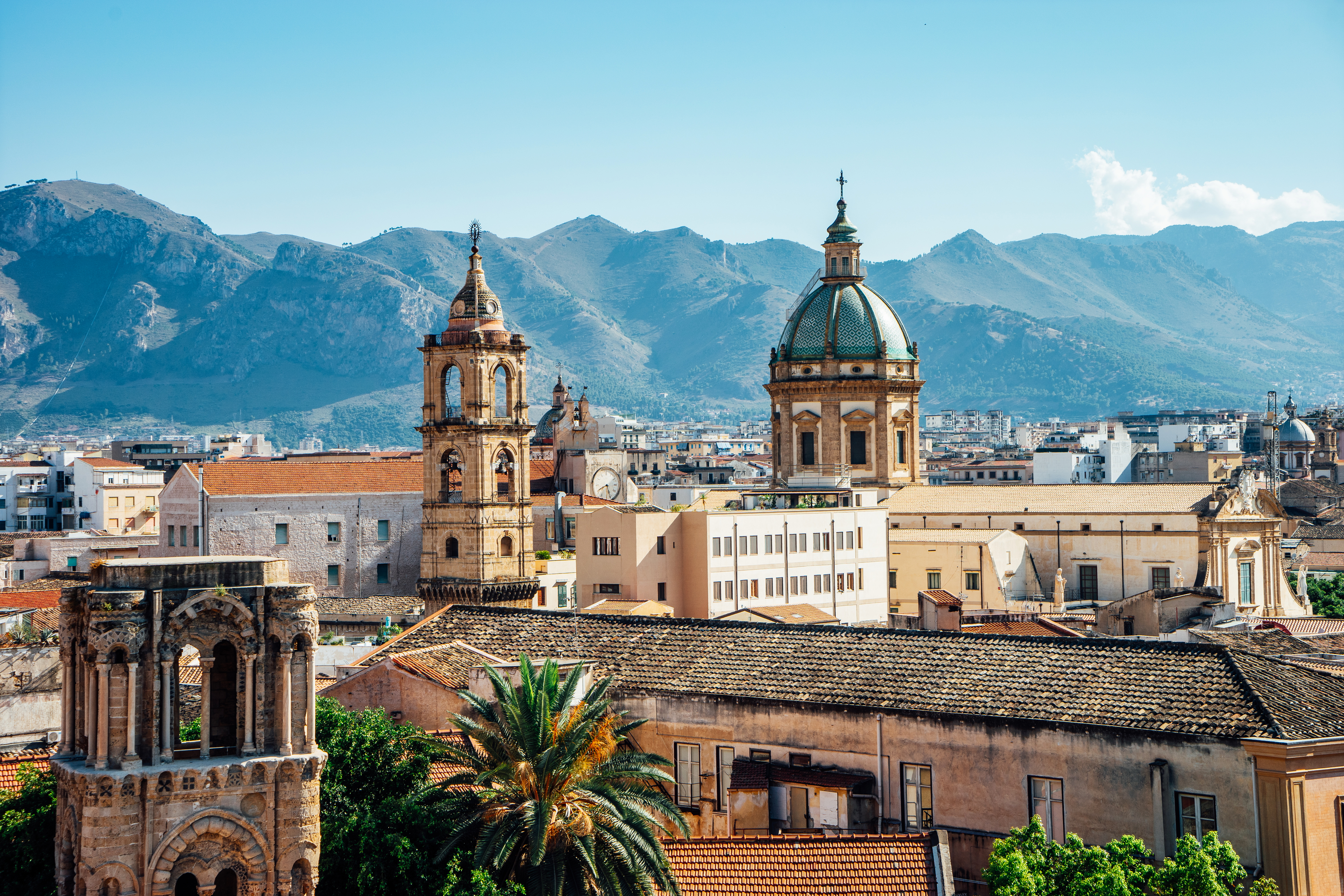 Palermo skyline with churches and mountains in the background.