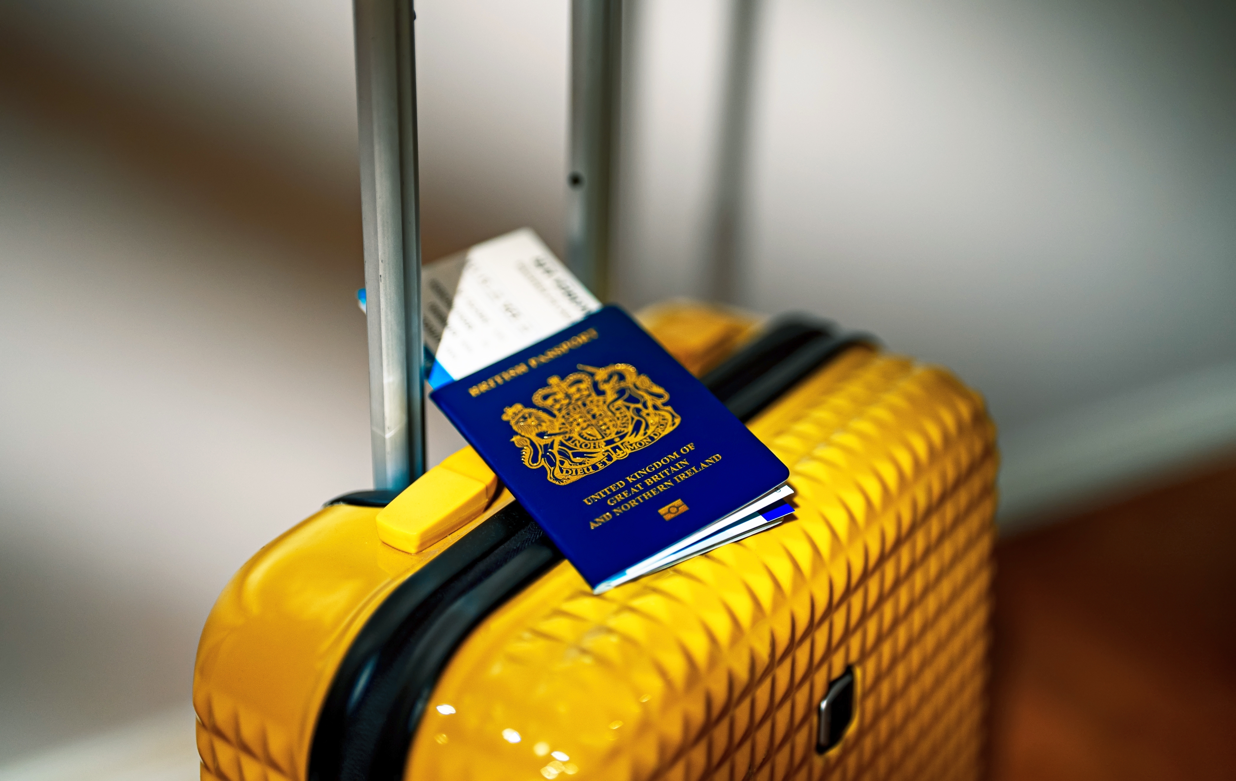 UK passport on yellow suitcase.