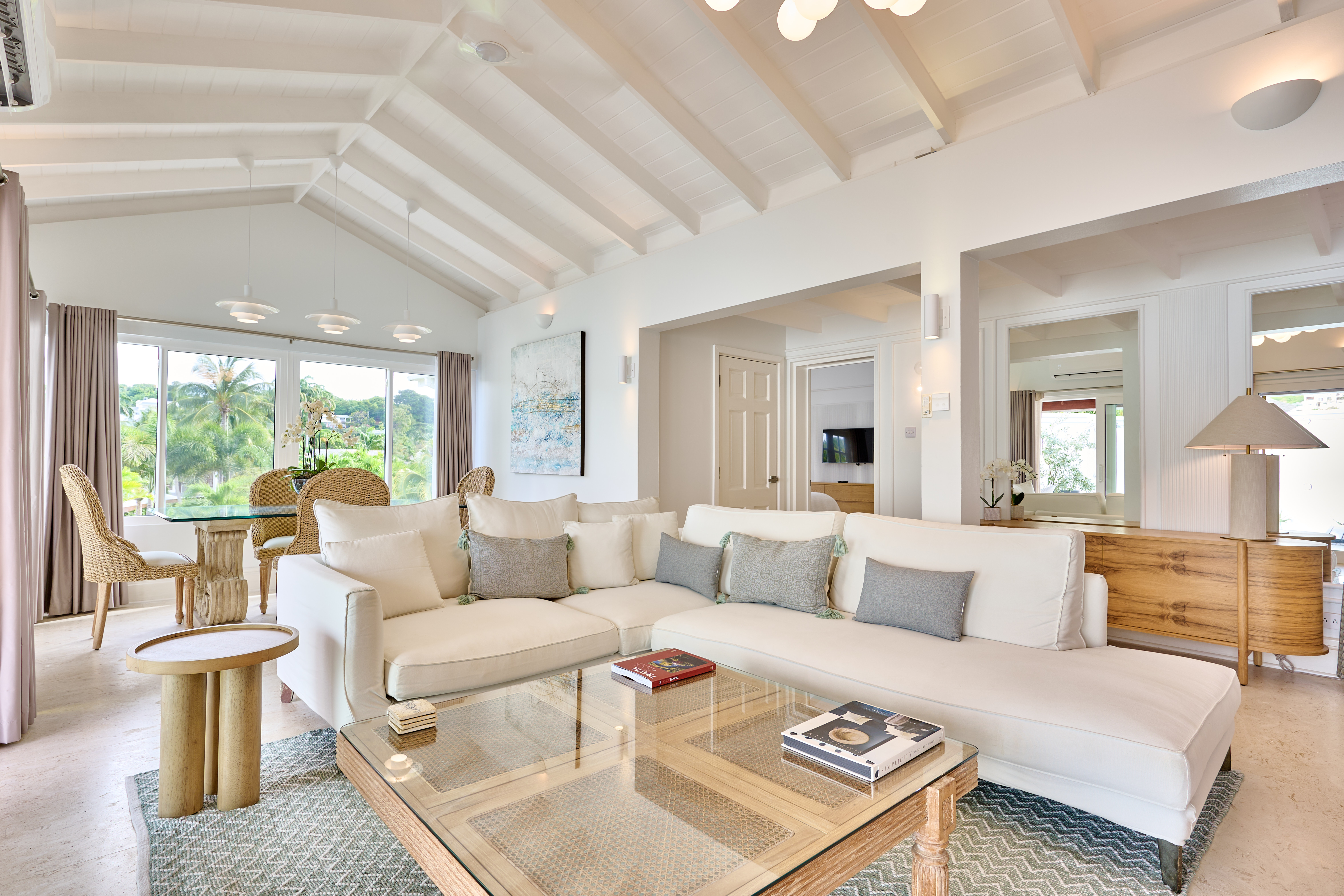 Living room with white sectional sofa and glass-top coffee table.