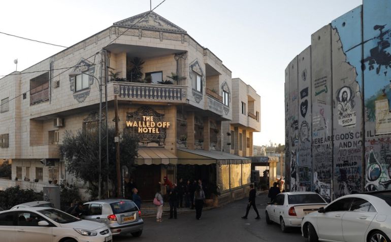 British artist Banksy's Walled-Off Hotel facing Israel's apartheid wall in the occupied West Bank town of Bethlehem. [Ahmad Gharabli/AFP]
