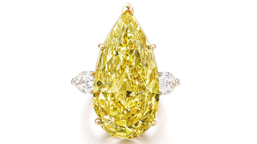 This ring bears a pear-shaped, 29.75-carat, fancy-intense-yellow diamond between two pear-shaped diamonds by Sotheby's image